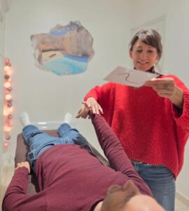 Client regardant une carte visuelle de symboles de motivation en séance de kinésiologie.