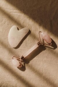 guasha et rouleau de massage en quartz rose utilisés en Kobido pour le soin du visage